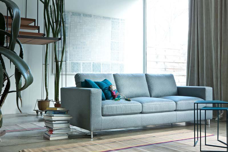 Un soggiorno con un divano grigio e tavolini blu
