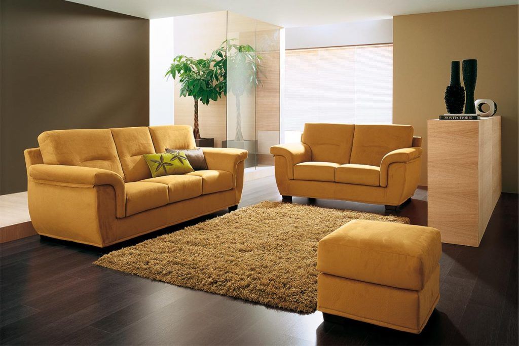 Un soggiorno con mobili gialli e un tappeto