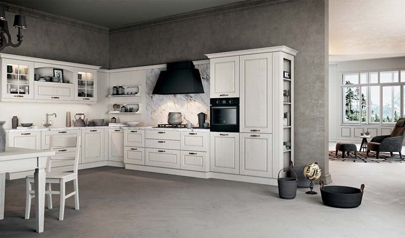 Una cucina con mobili bianchi e una cappa nera