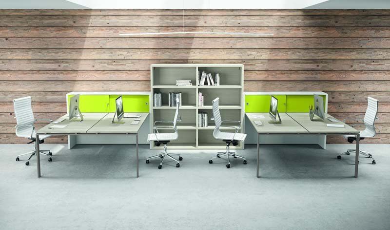 Una fila di scrivanie con computer e sedie in un ufficio