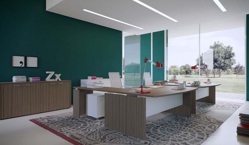 Un ufficio moderno con un grande tavolo, sedie e una parete verde.