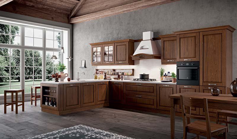 Una cucina con mobili in legno, tavolo e sedie