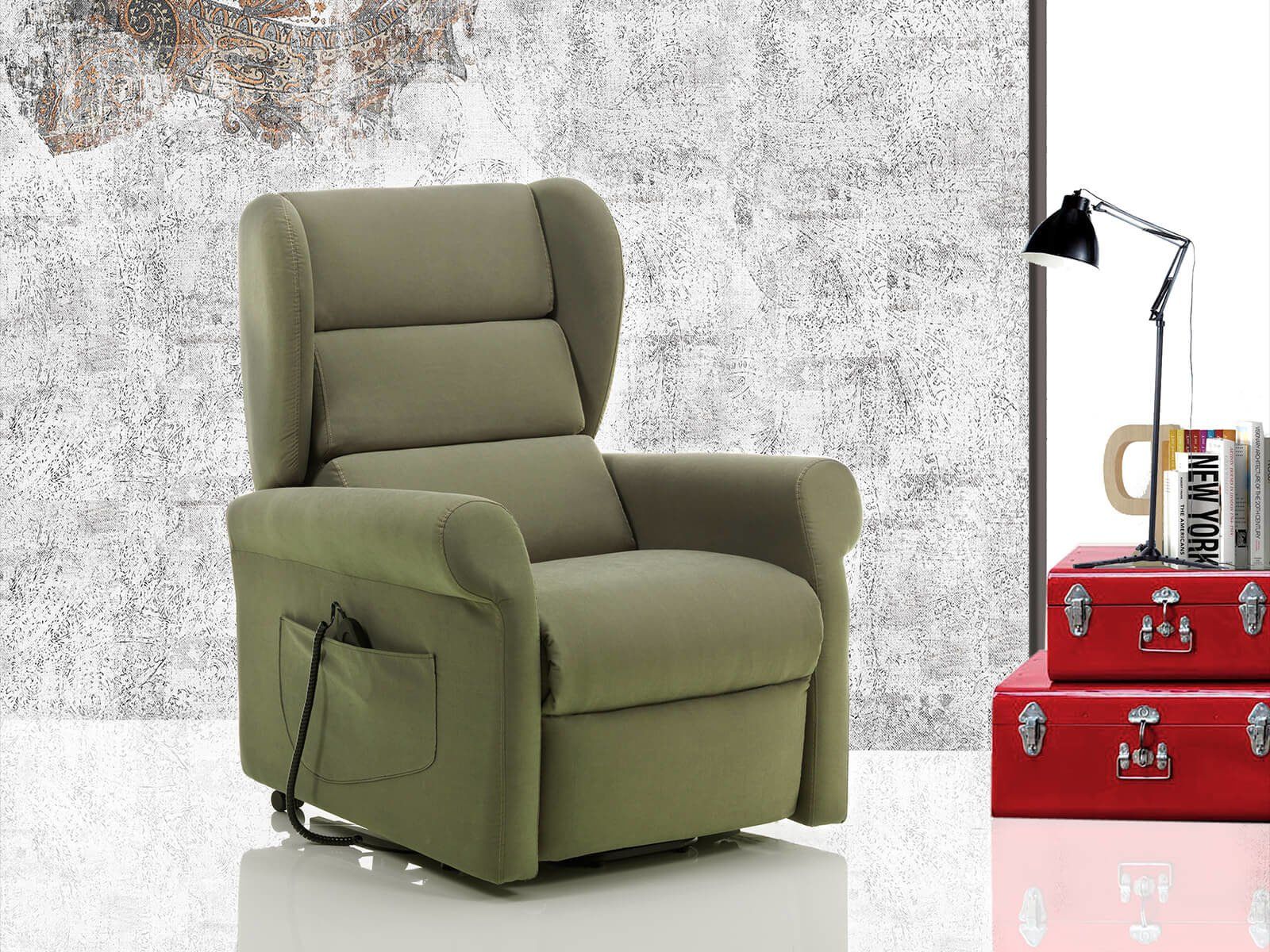 Una poltrona reclinabile verde è seduta accanto a una valigia rossa e una lampada
