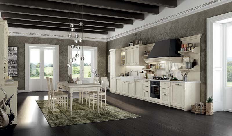 Una cucina con mobili bianchi, tavolo da pranzo e sedie.