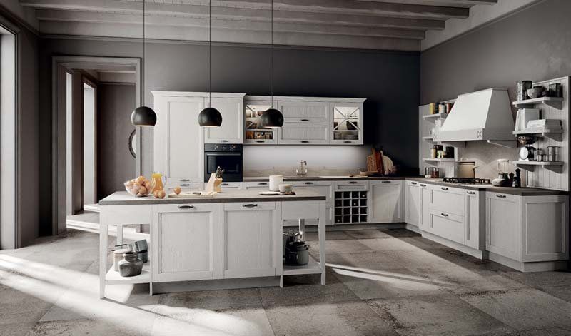 Una cucina con mobili bianchi e una grande isola al centro.