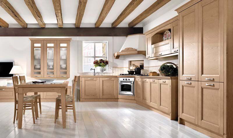 Una cucina con mobili in legno, tavolo e sedie