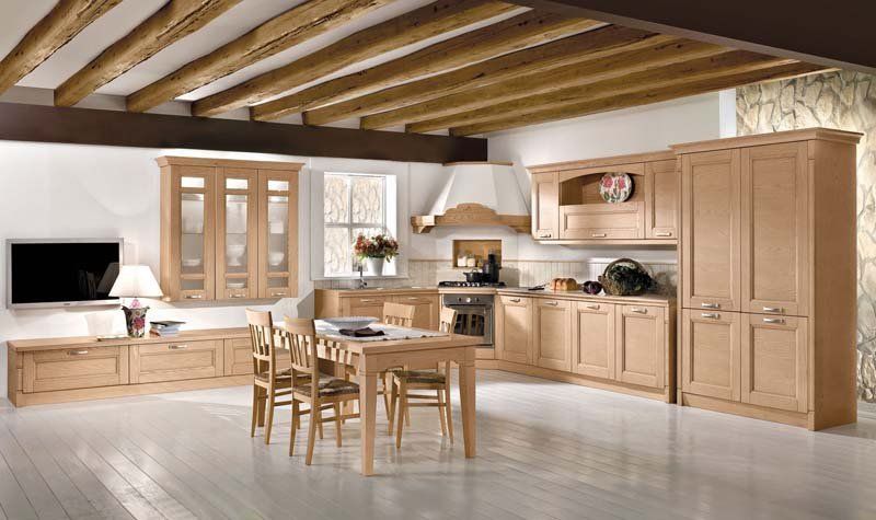 Una cucina con mobili in legno, tavolo e sedie