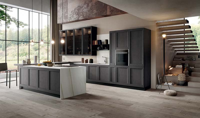 Una cucina con una grande isola al centro e delle scale che vi portano.