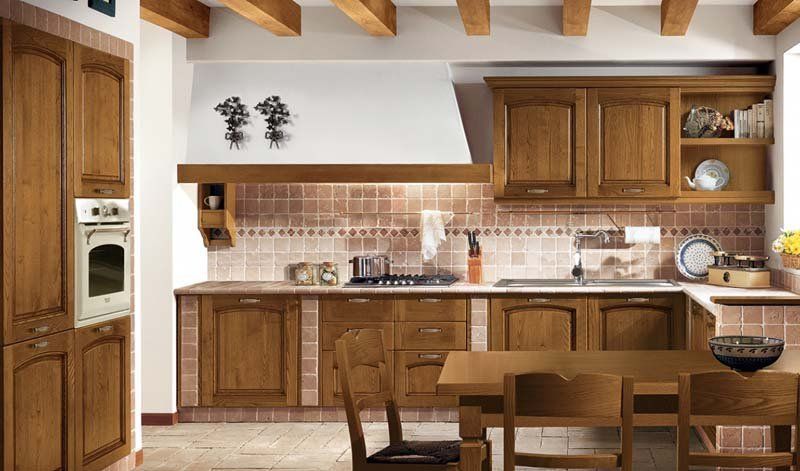 Una cucina con mobili in legno, tavolo e sedie