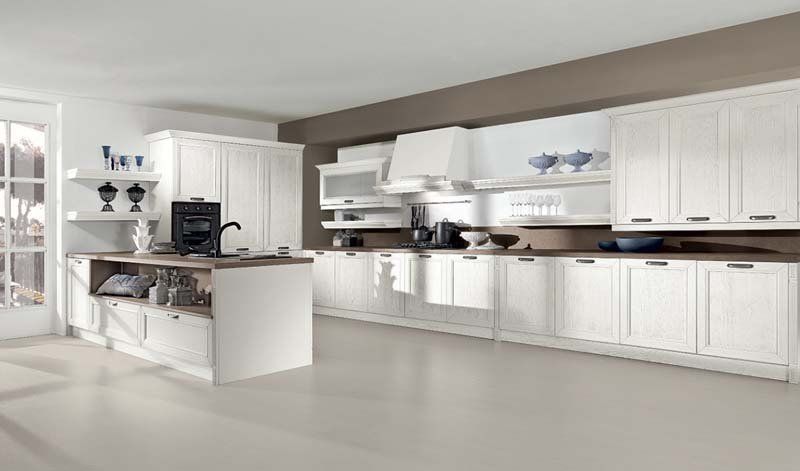 Una cucina con mobili bianchi e una grande isola al centro
