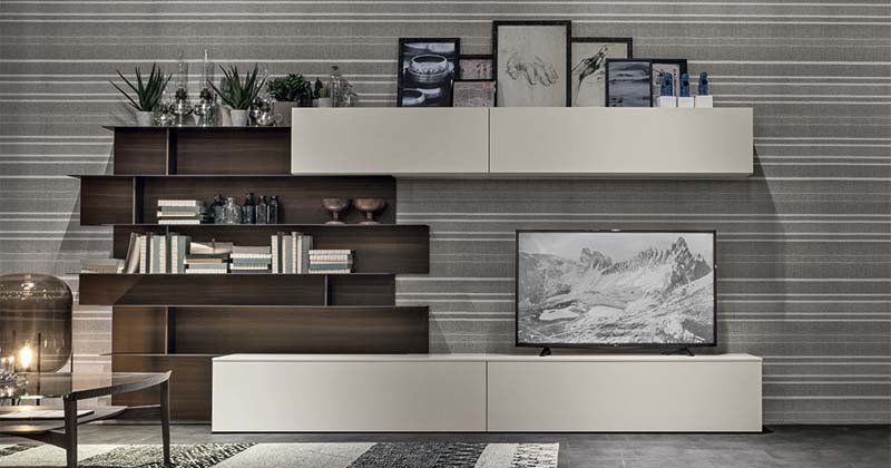 Un soggiorno con un centro di intrattenimento montato a parete e una TV a schermo piatto.