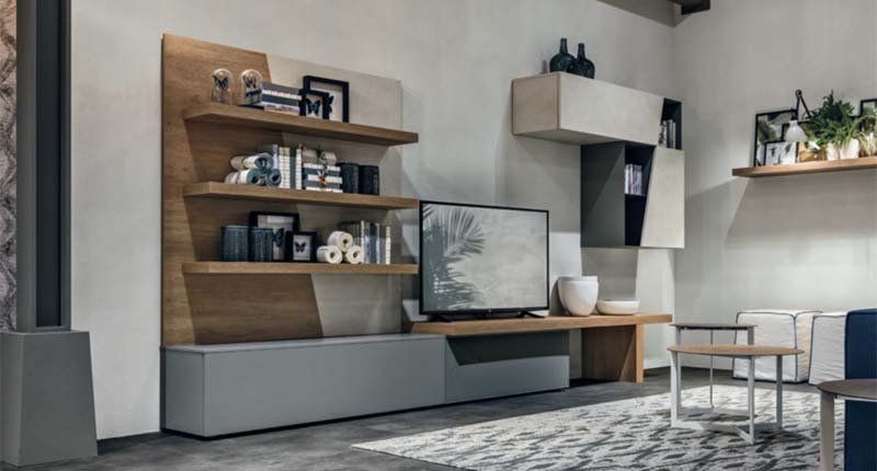 Un soggiorno con una TV su un supporto e degli scaffali.