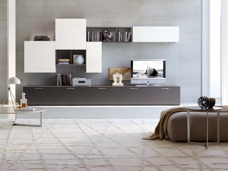 Un soggiorno con un divano e una tv sul muro