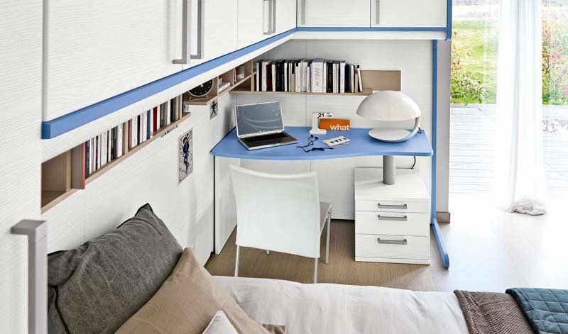 Una camera da letto con una scrivania con un computer portatile sopra