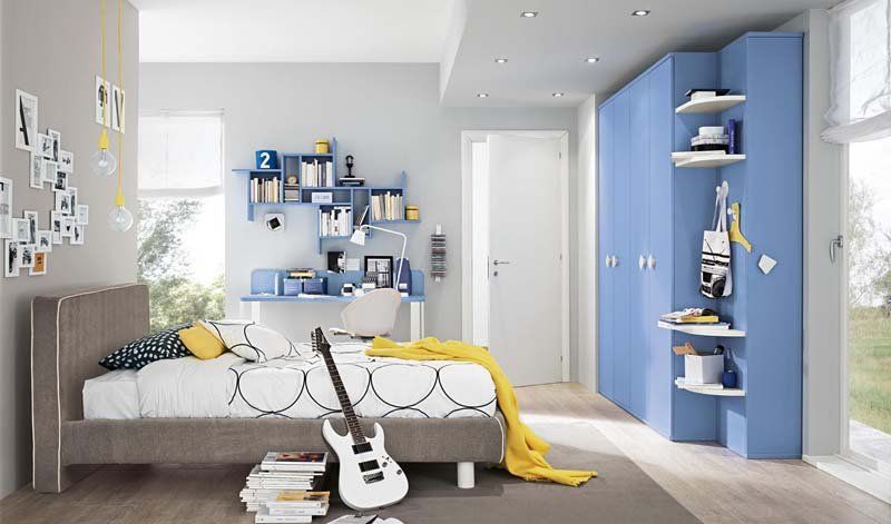 Una camera da letto con un letto, un armadio, una scrivania e una chitarra.