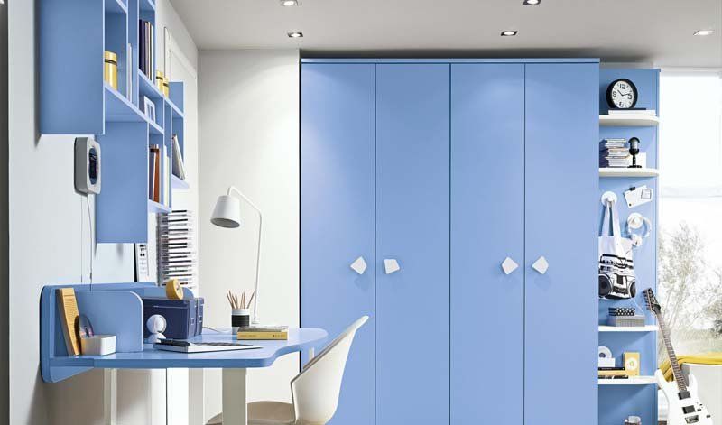 Una stanza con armadi blu, una scrivania e una sedia