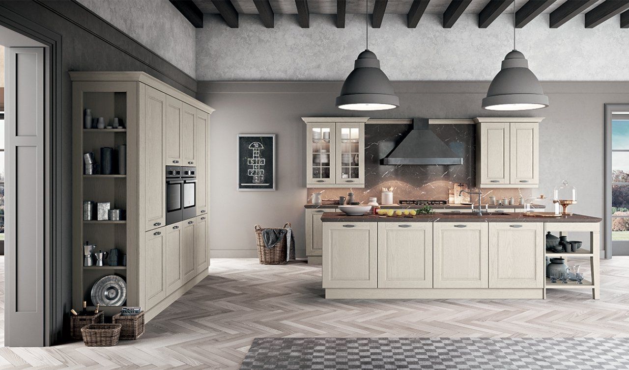 Una cucina con mobili bianchi e una grande isola al centro della stanza.