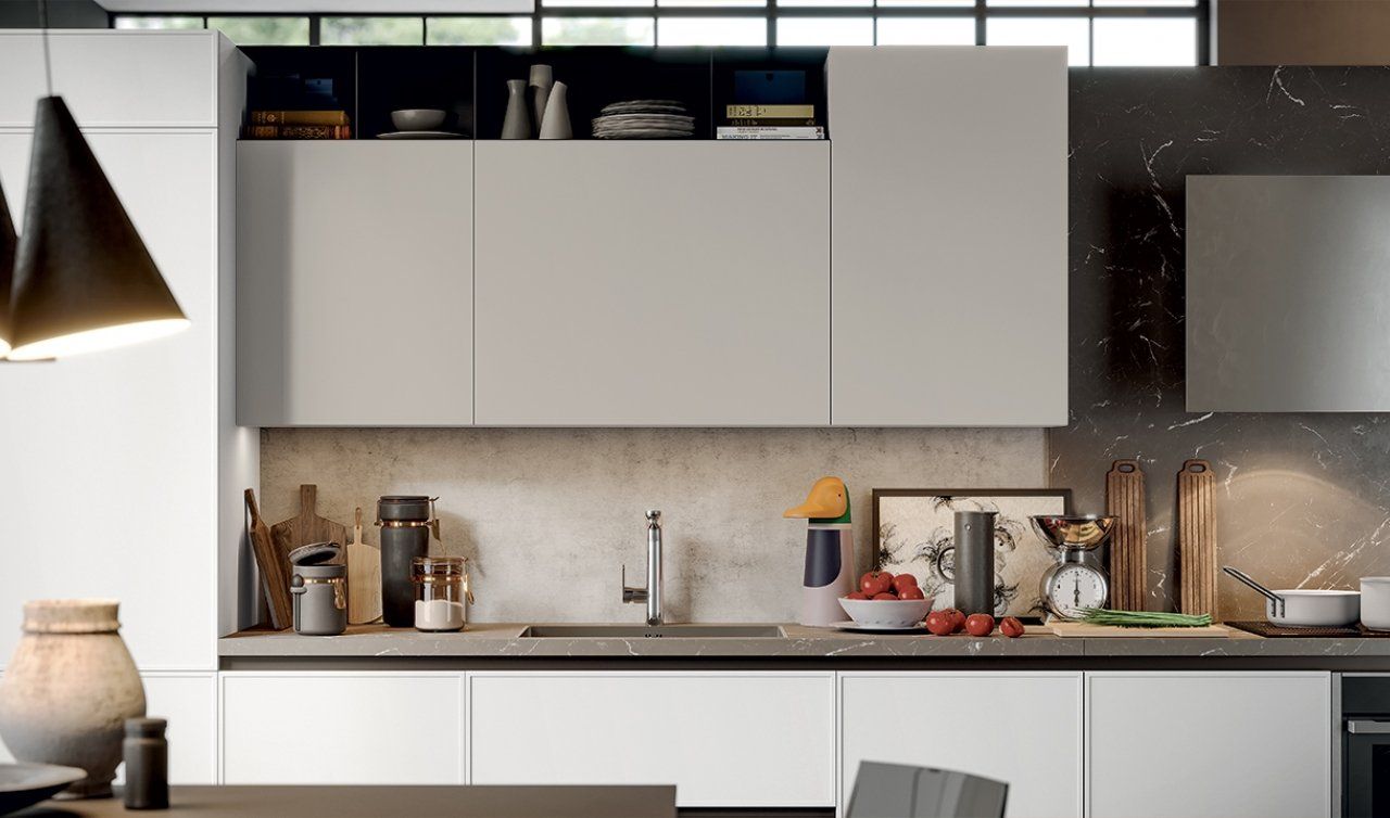 Una cucina con mobili bianchi e un lavandino