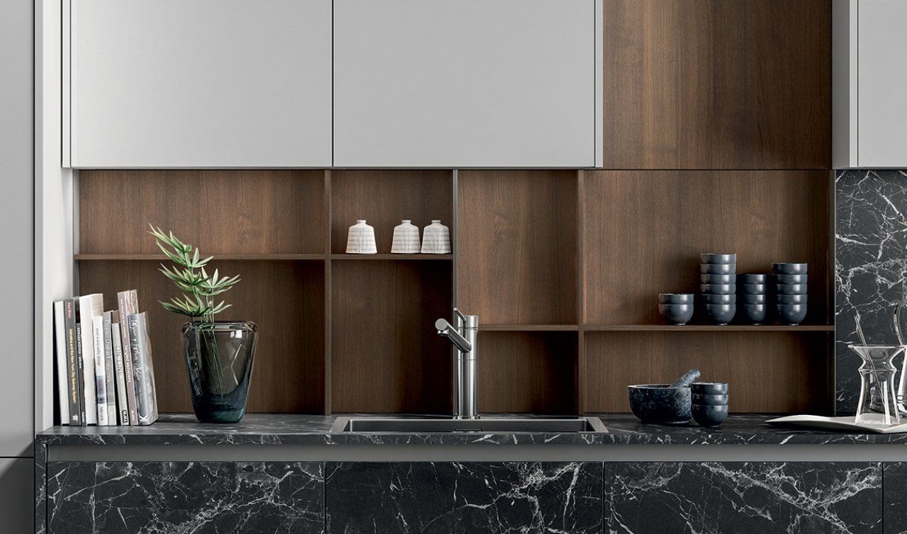 Una cucina con un lavandino, degli scaffali e una pianta in vaso.