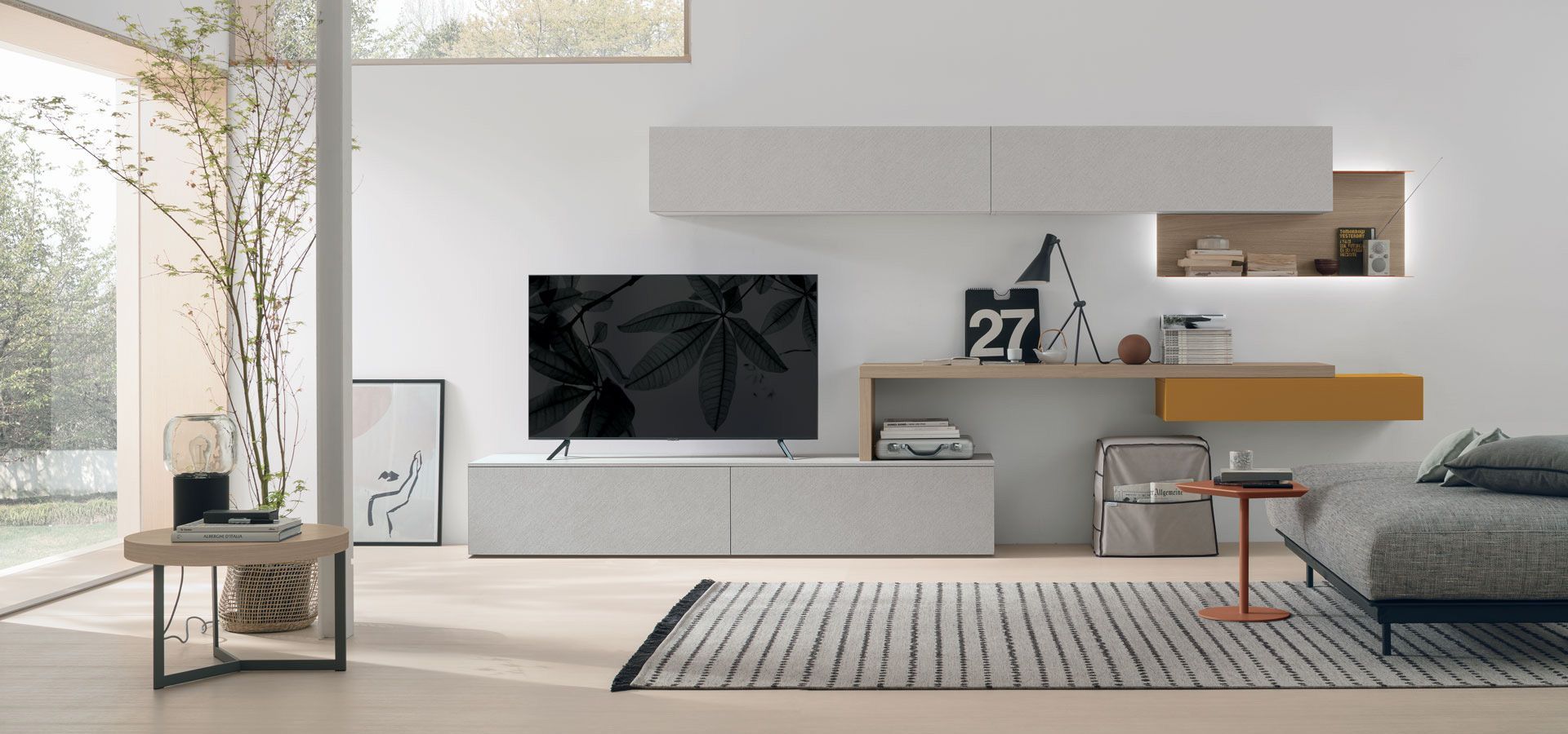 Un soggiorno con TV a schermo piatto e divano.