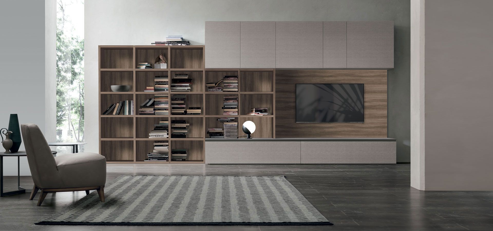 Un soggiorno con un tappeto, una sedia, una libreria e una televisione.