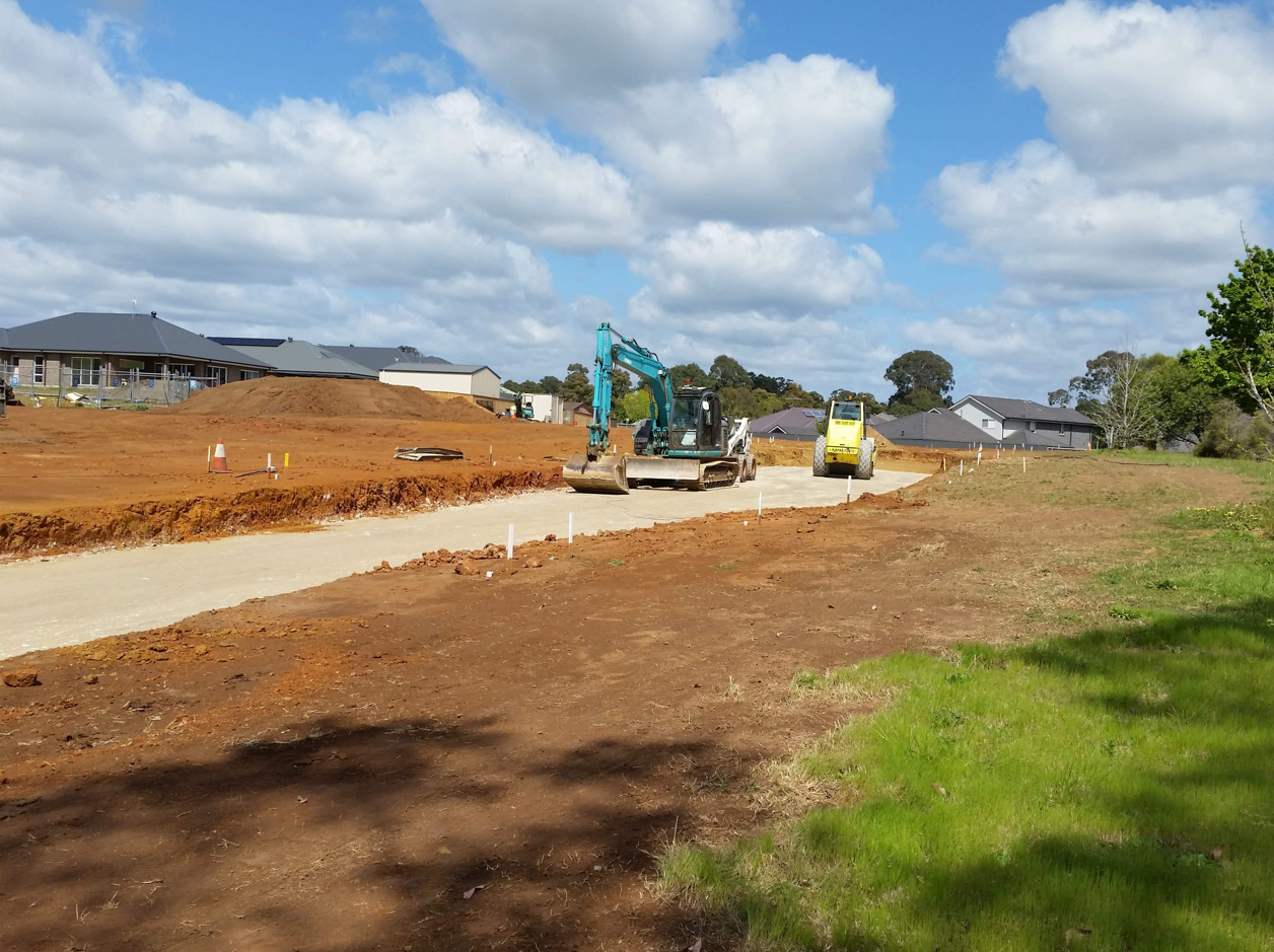 A construction site with a lot of dirt and buildings in the background.