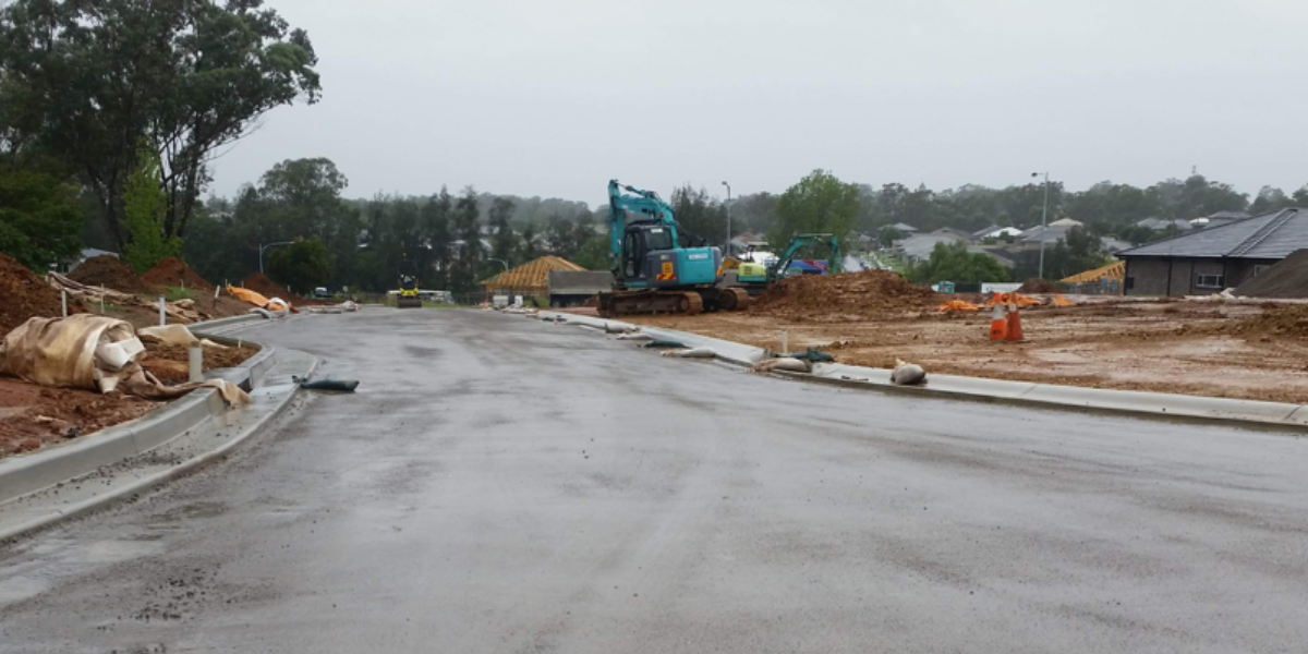 A construction site with a bulldozer on the side of the road.
