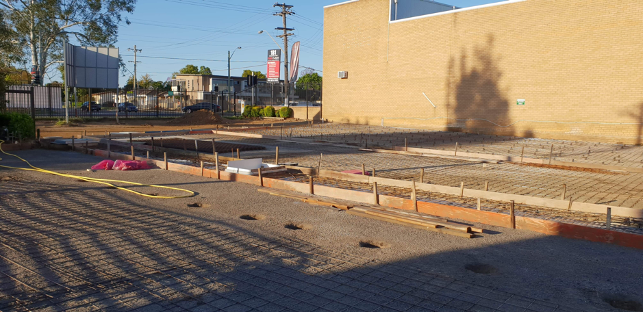 A construction site with a brick building in the background.