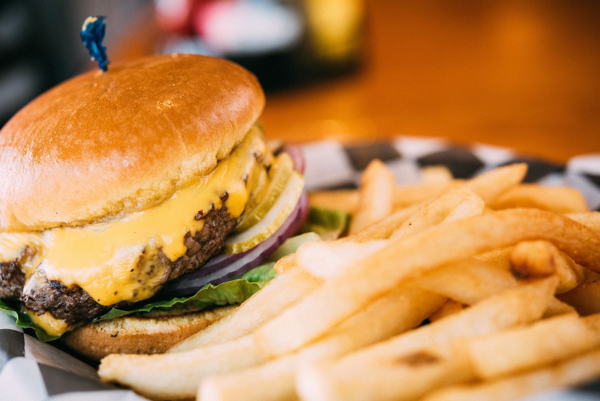 Cheeseburger with fries in a checkered basket.