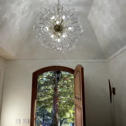 A large chandelier is hanging from the ceiling above a door.