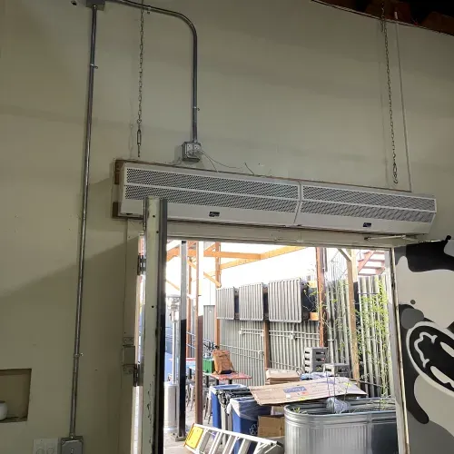 A large air conditioner is hanging from the ceiling above a door.