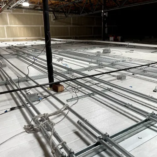 There are a lot of wires hanging from the ceiling of a building.