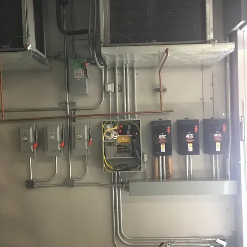 A room with a lot of electrical wires hanging from the ceiling.