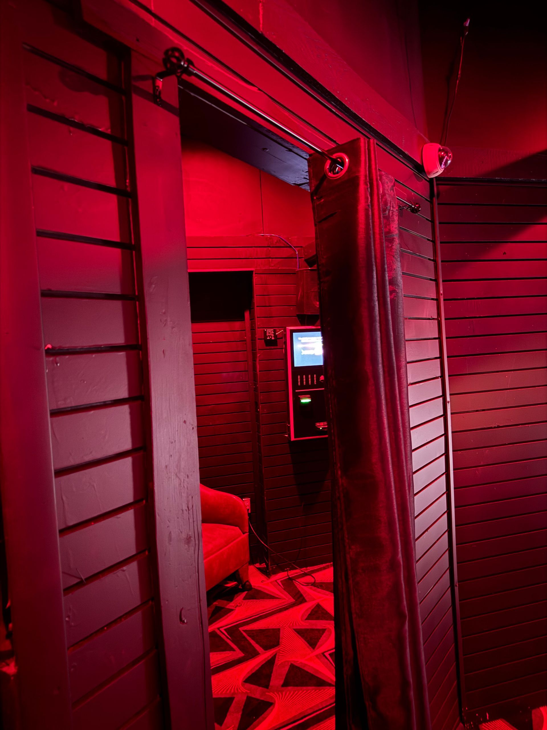 A doorway leading to a room with red walls and a television.