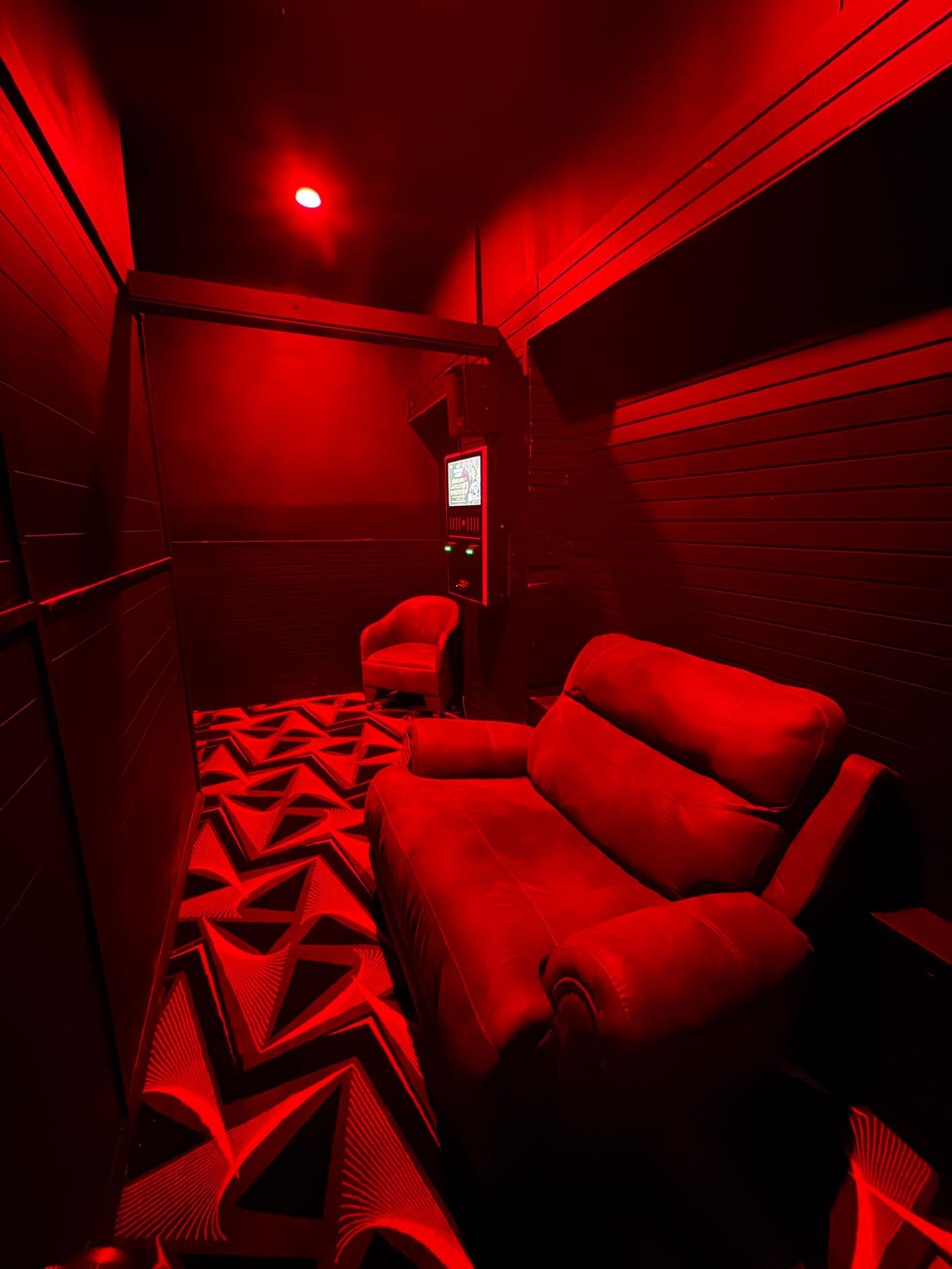There is a red couch in the middle of the room.