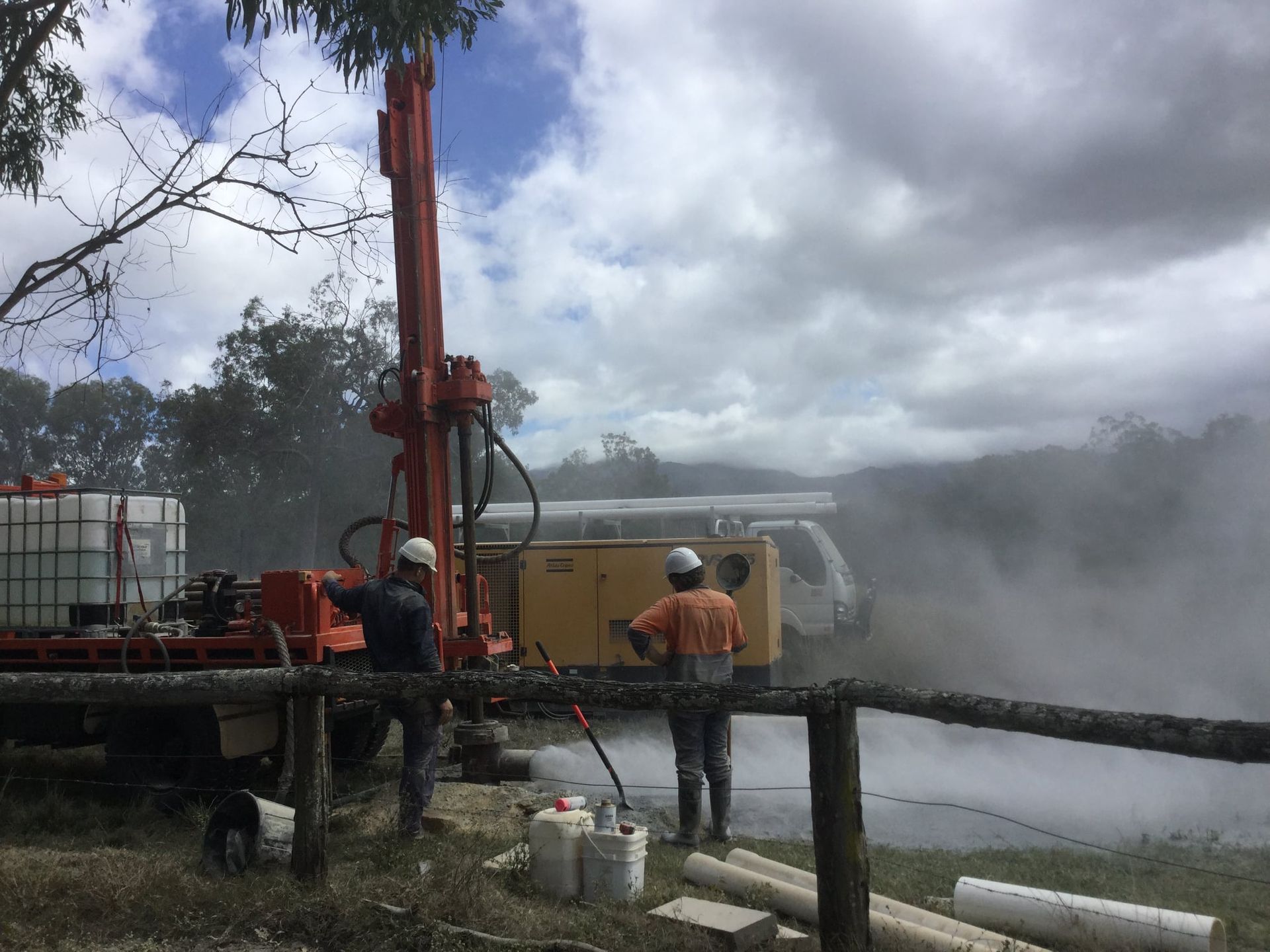 Small Yellow Excavator Is Parked Next To A Power Pole — FNQ Drilling in Babinda, QLD
