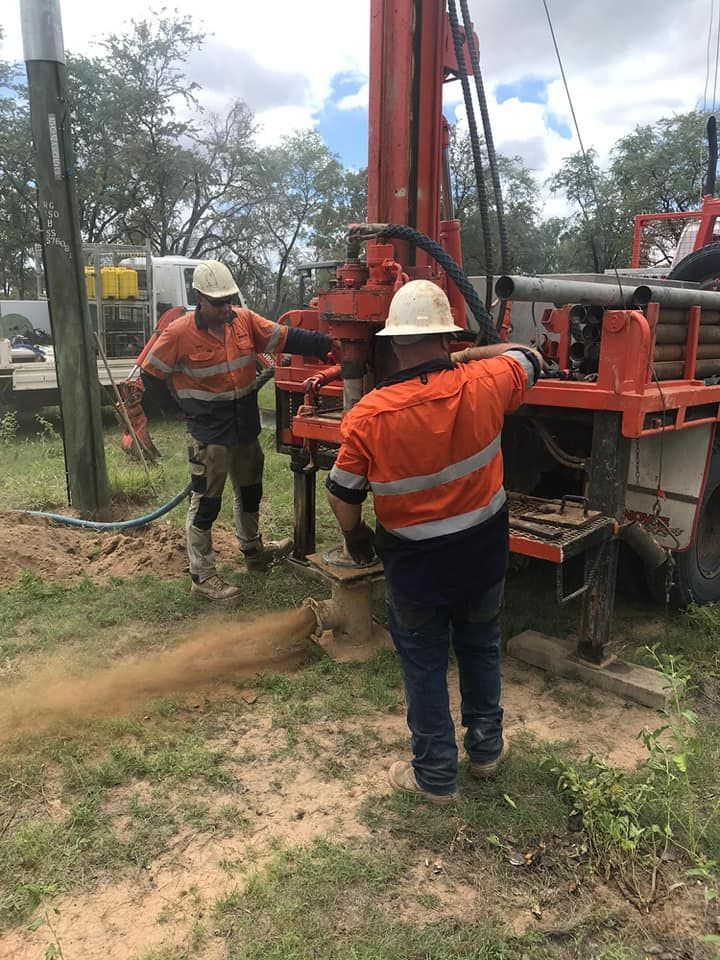 Two Men Are Working On A Drilling Machine In A Field — FNQ Drilling in Bamboo, QLD