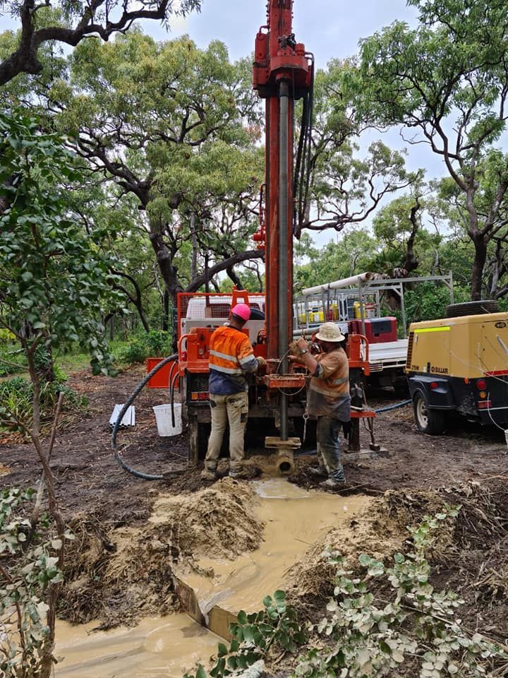 A Group of Men Are Working on A Drilling Rig in The Dirt — FNQ Drilling in Bamboo, QLD