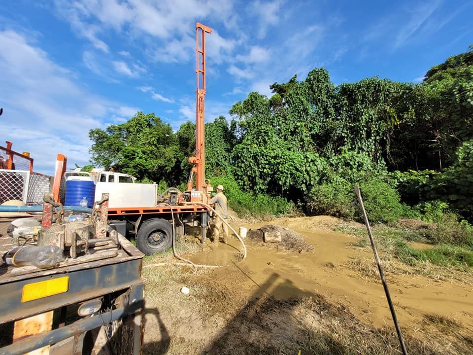 A Truck Is Driving Down A Dirt Road Next To A Drilling Rig — FNQ Drilling in Georgetown, QLD