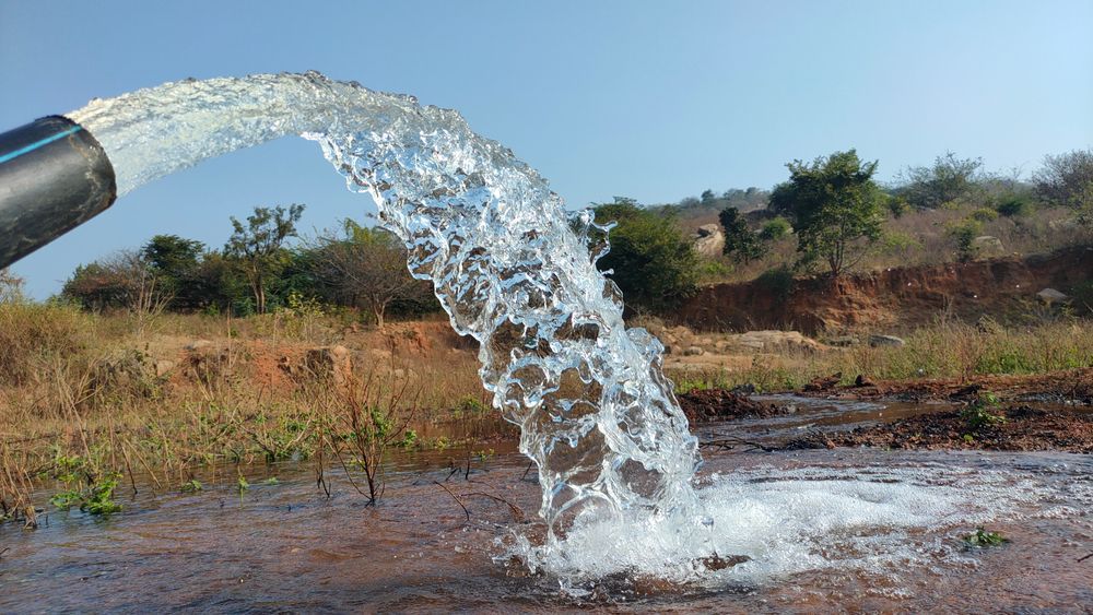 Water Gushing From a Black Pipe Into a Pool — FNQ Drilling in Cairns, QLD
