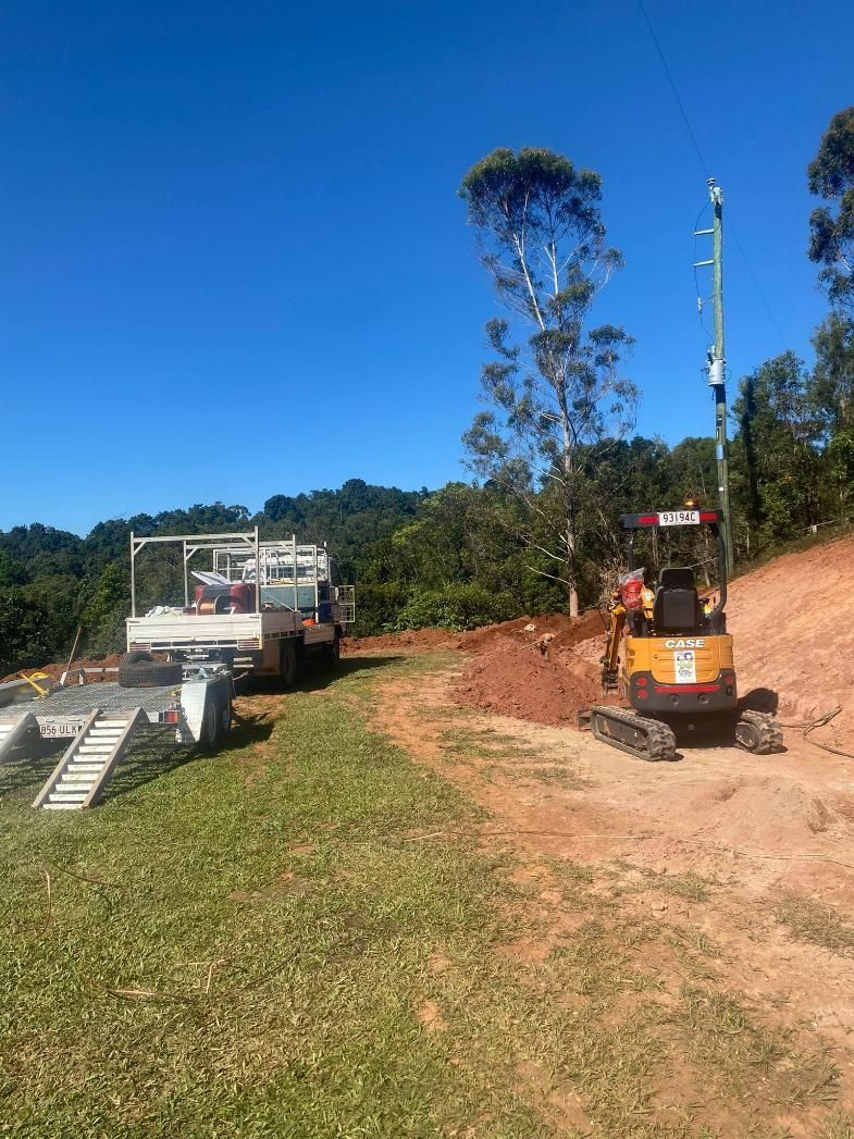 A Yellow Excavator is Working on a Construction Site — FNQ Drilling in Mareeba, QLD