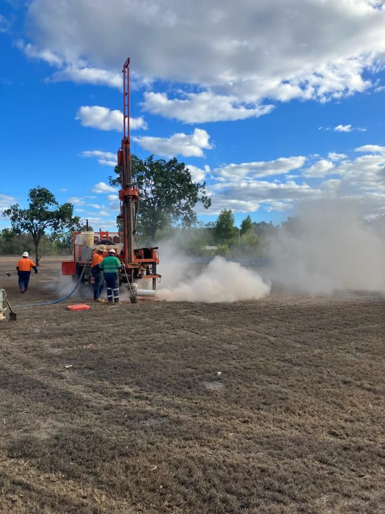Man Is Standing Next To A Pipe With Smoke Coming Out Of It — FNQ Drilling in Cairns, QLD
