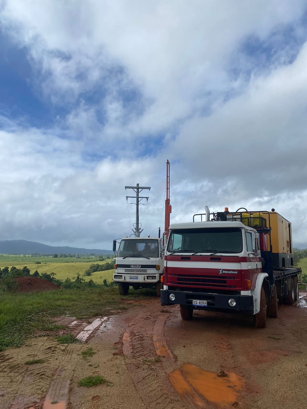 Two Trucks Are Parked Next to Each Other on a Dirt Road — FNQ Drilling in Innisfail, QLD