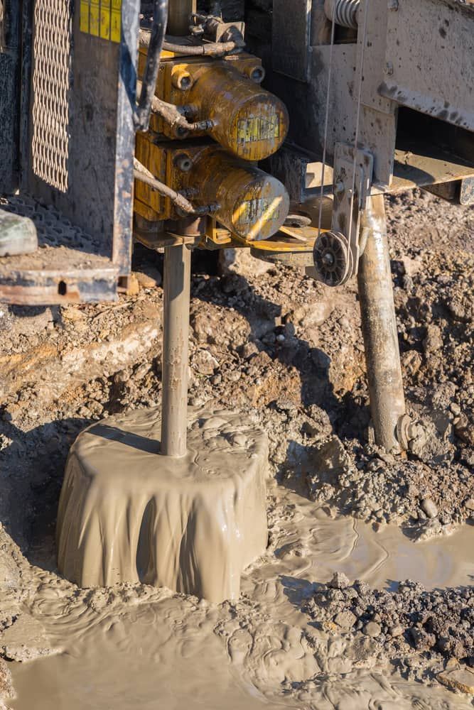Small Yellow Excavator Is Parked Next To A Power Pole — FNQ Drilling in Georgetown, QLD