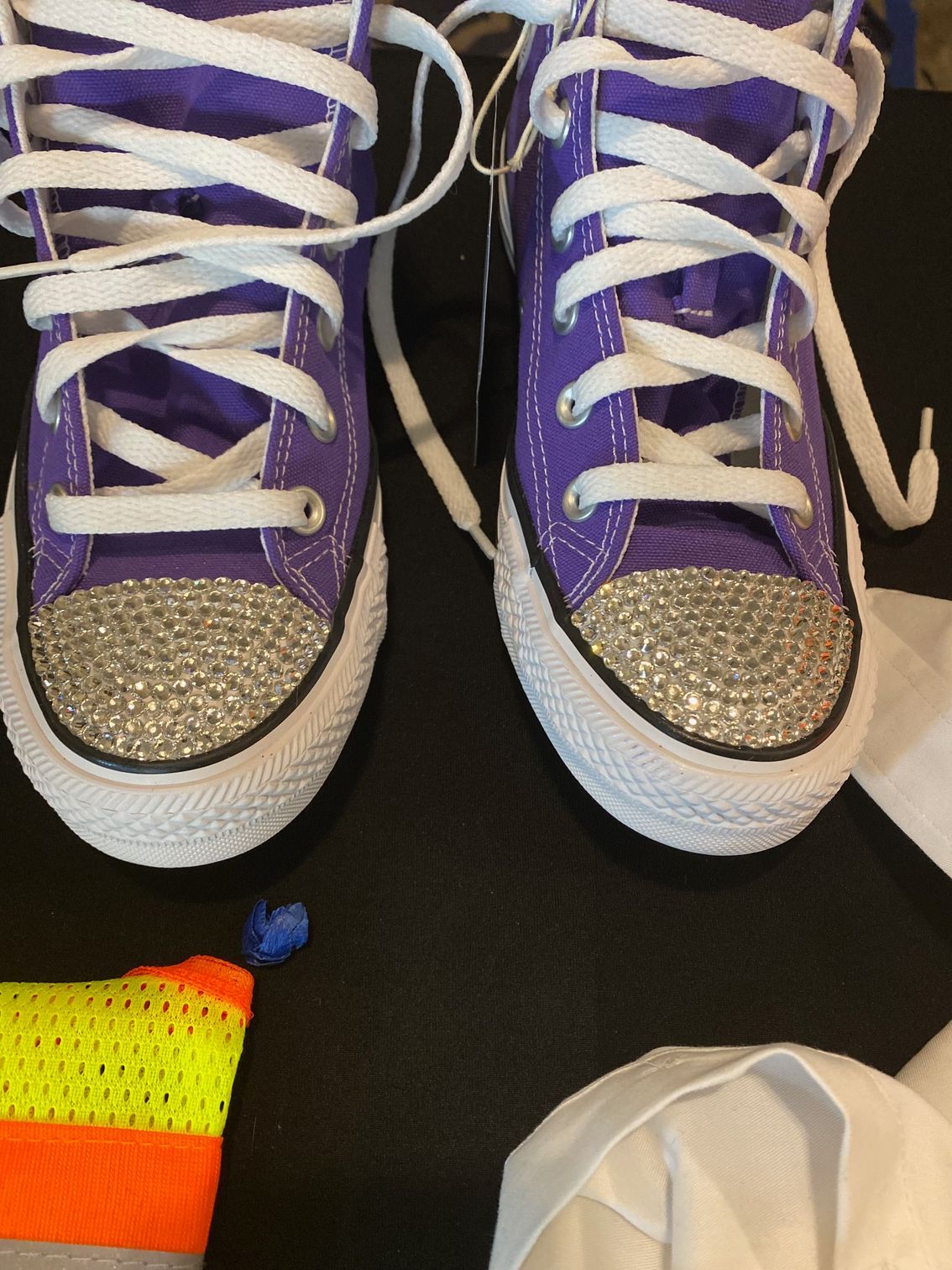 A pair of purple converse shoes with white laces