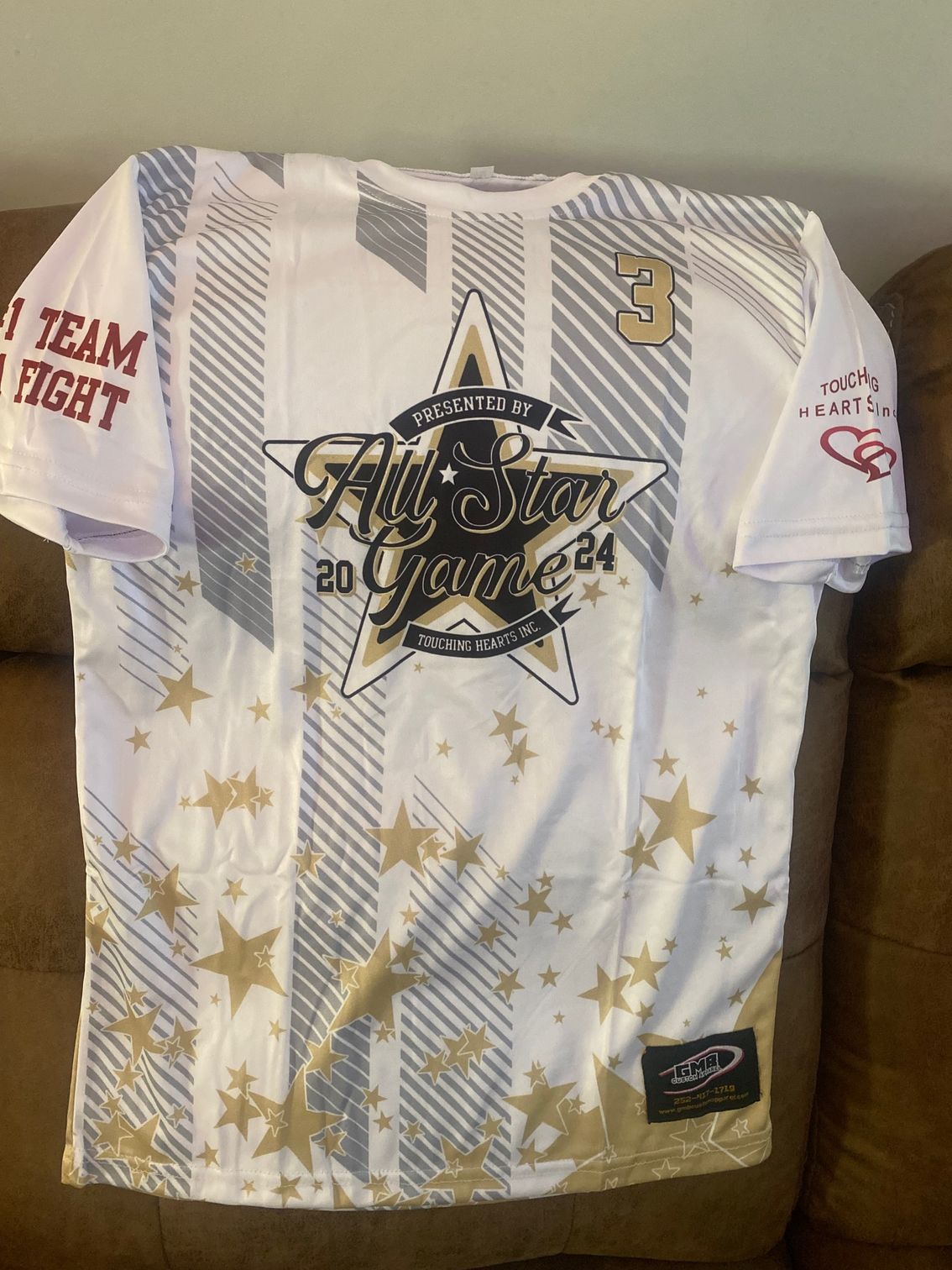 A white t-shirt with gold stars and the number 3 on it
