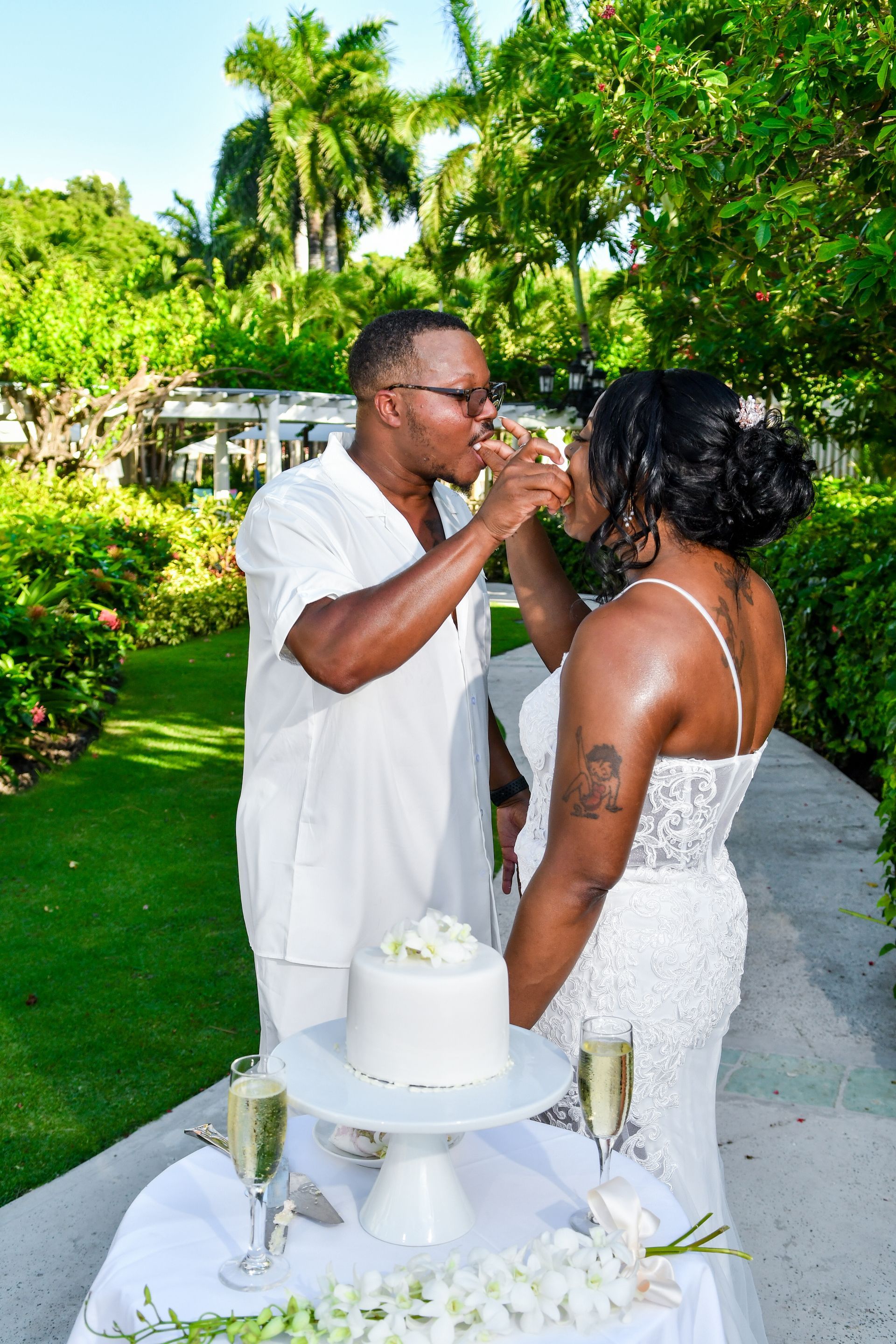 A man and a woman are toasting with champagne at a wedding cake table.