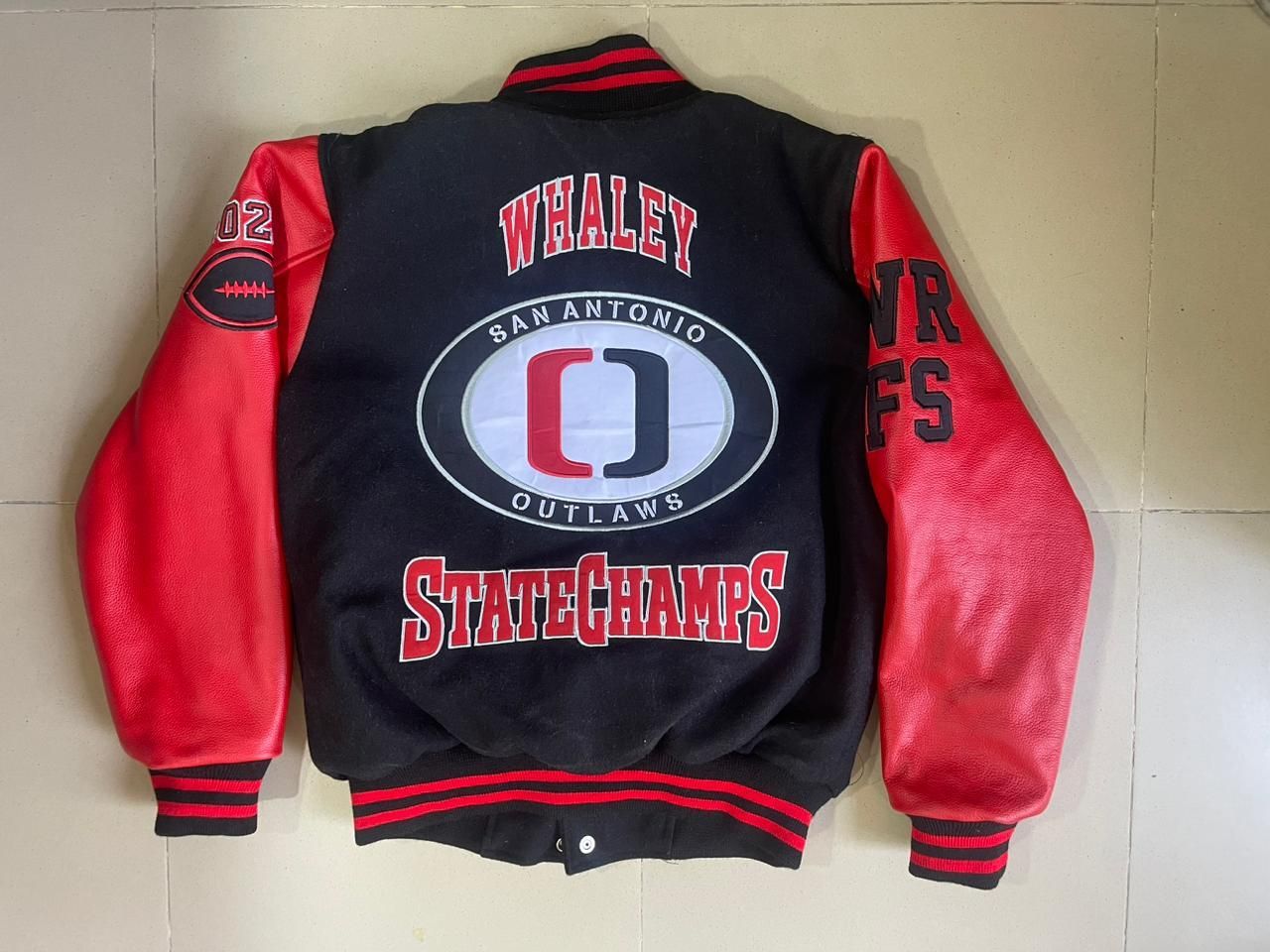 A black and red varsity jacket with the word statechamps on the back