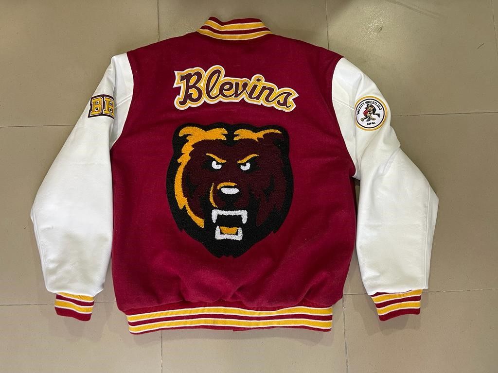 A maroon and white varsity jacket with a bear on the back