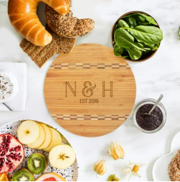 A wooden cutting board with the initials n & h on it
